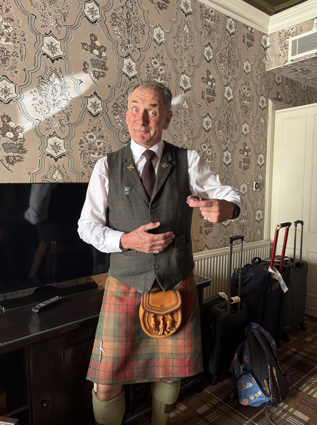 Gleneagles Hotel staff member wearing a traditional Scottish kilt while welcoming guests.