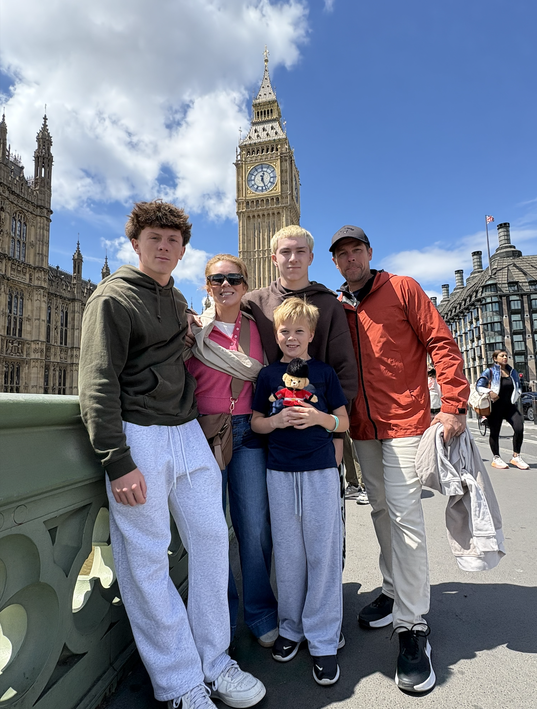 Family posing in front of Big Ben and the Palace of Westminster in London, England.
