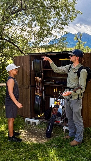A family enjoying a guided archery experience at a luxury ranch in Montana.