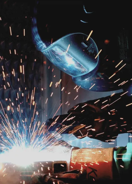 Welder with hood and sparks flying