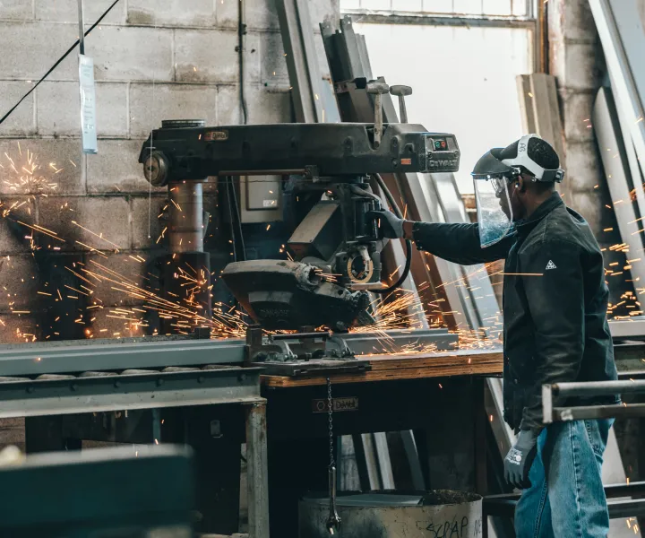 Worker with face shield working with machinery