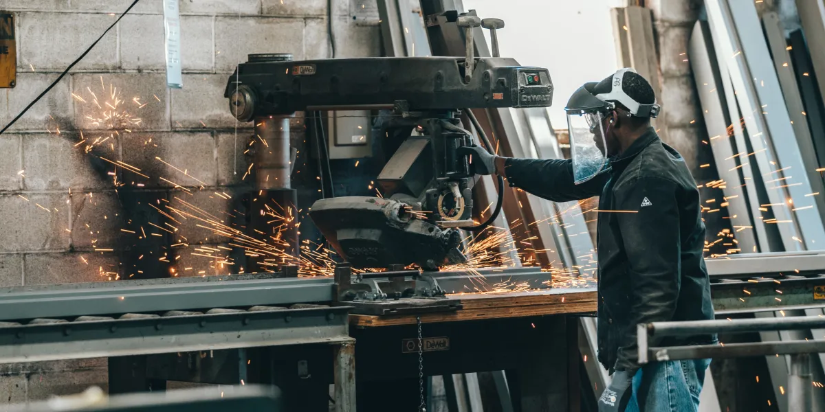 Worker with face shield working with machinery