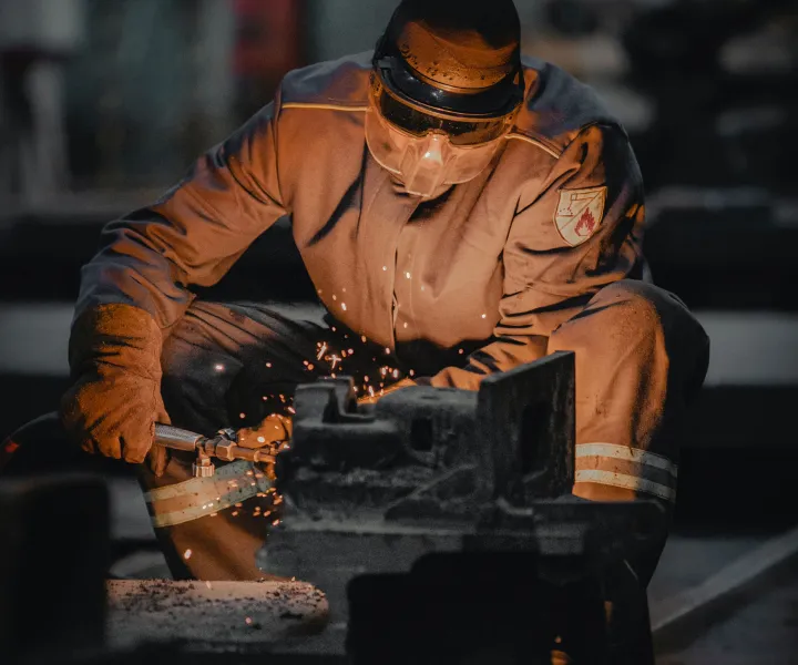 Welder kneeling down working on a weld