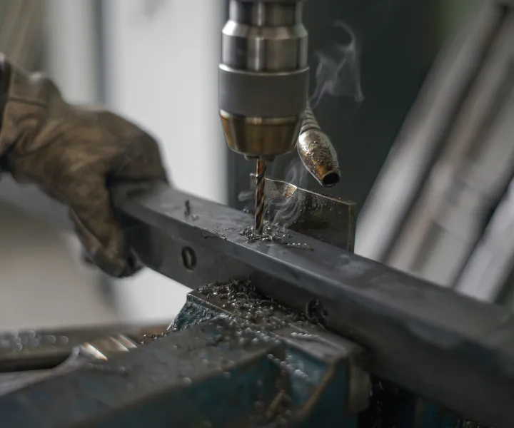 Worker hold metal while drilling