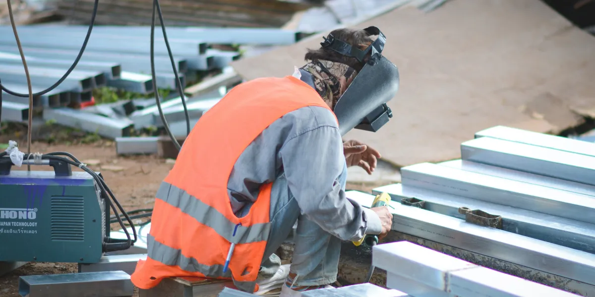 Welder with face shield grinding metal