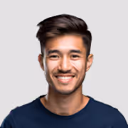 Smiling young man with dark hair wearing a navy blue shirt against a light gray background.