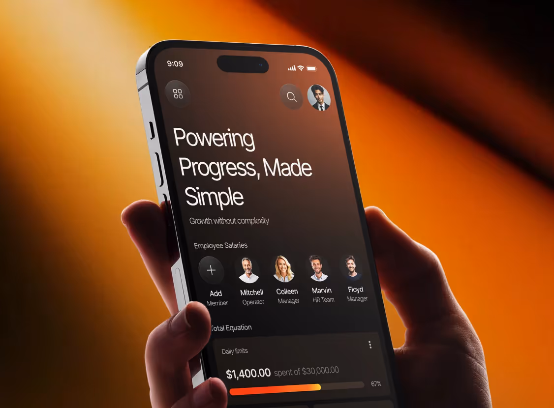 Hand holding a smartphone displaying a dashboard with the heading 'Powering Progress, Made Simple' and employee salary information with profile photos and spending limits.