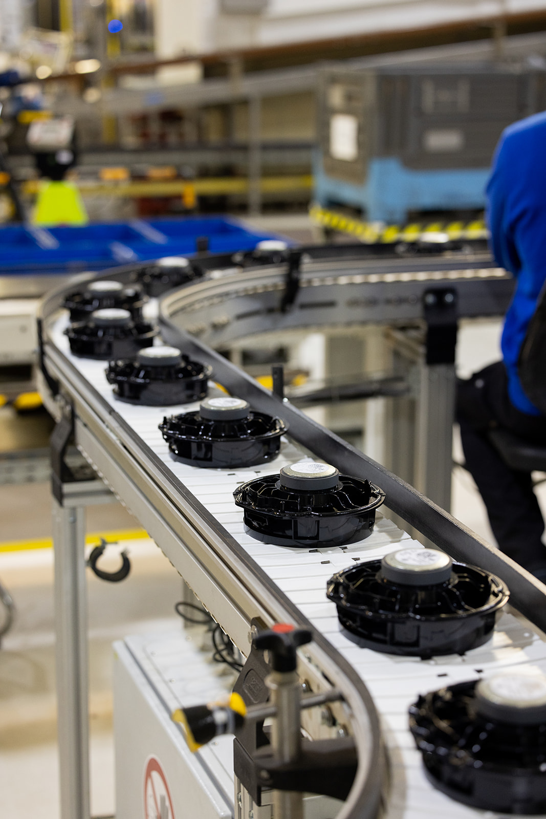 Custom testing equipment inside a safety-enclosed machine, including a black foam-covered microphone mounted in a blue-patterned ceramic cup.