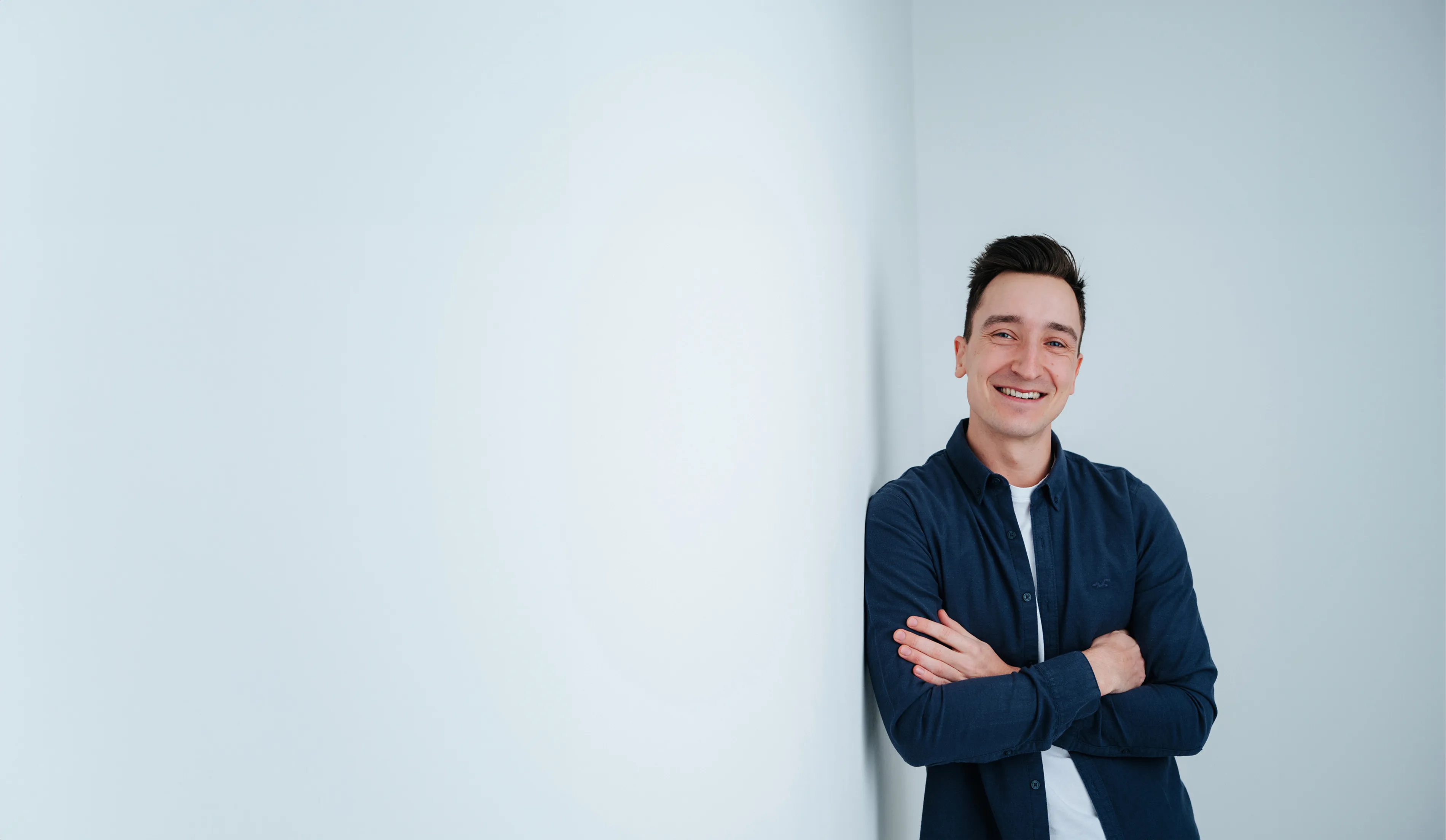Dominik Walder lehnt sich mit der Schulter an eine Wand und lächelt