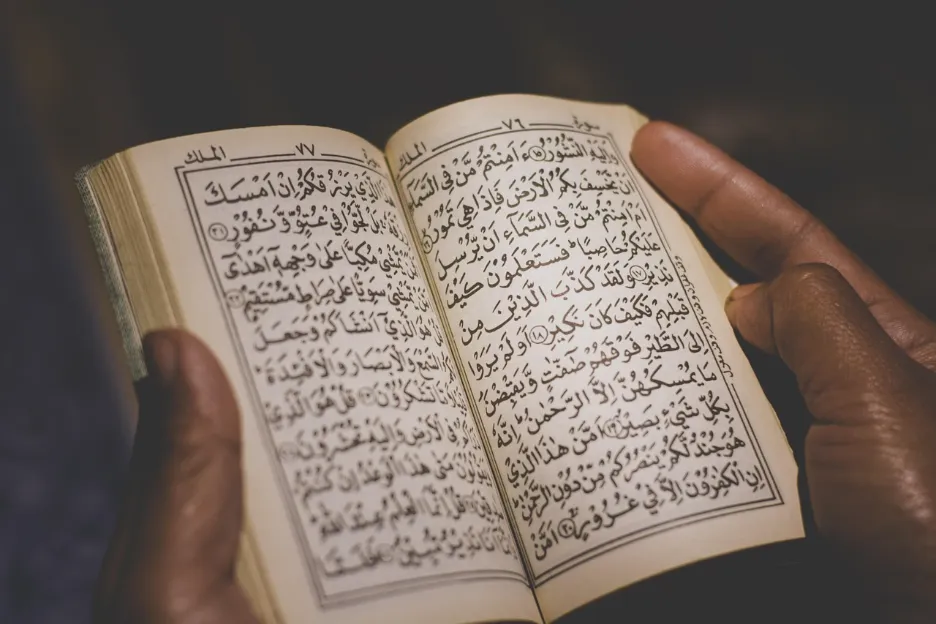 Hands holding an opened Qur'an, illustrating reading Duas for Protection from the Quran