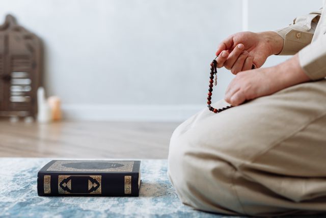 In the Remembrance of Allah, Hearts Find Peace Blog image: Close up of a person holding prayer beads