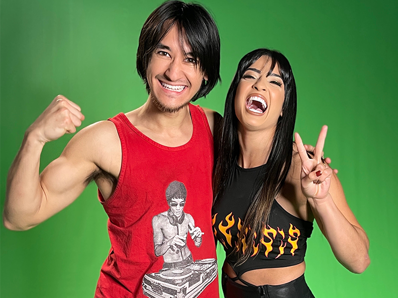 Flexing bicep peace sign Rita Reis aka Valentina Feroz Brazilian martial artist NXT WWE pro wrestler and PJ DJ Trakataka turntablist disc jockey