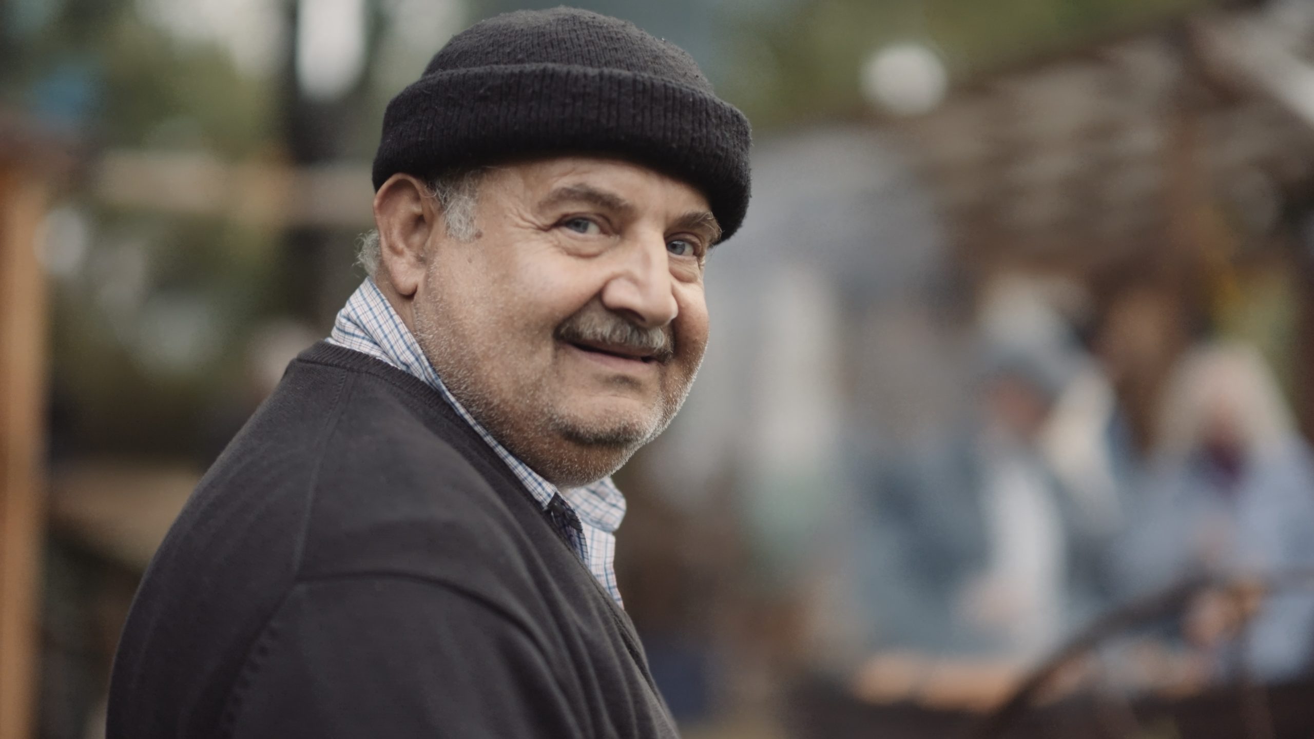 En eldre mann som smiler til kamera.