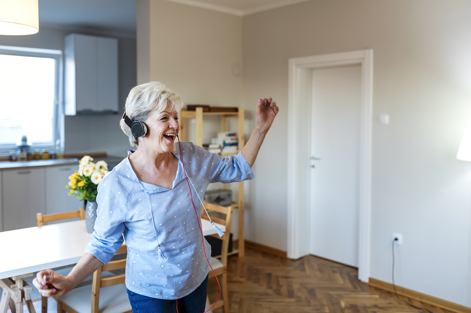 Kvinne som danser med høretelefoner i øret.
