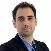 A man in a suit and tie posing for a picture.