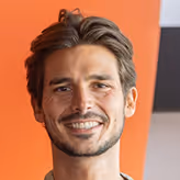 A man with a goatee smiles at the camera.