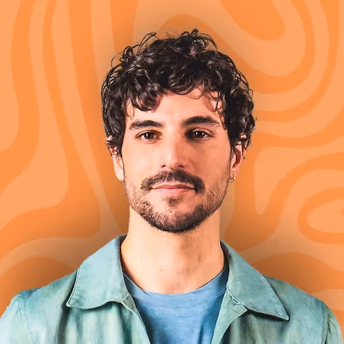 A man with curly hair wearing a blue shirt.