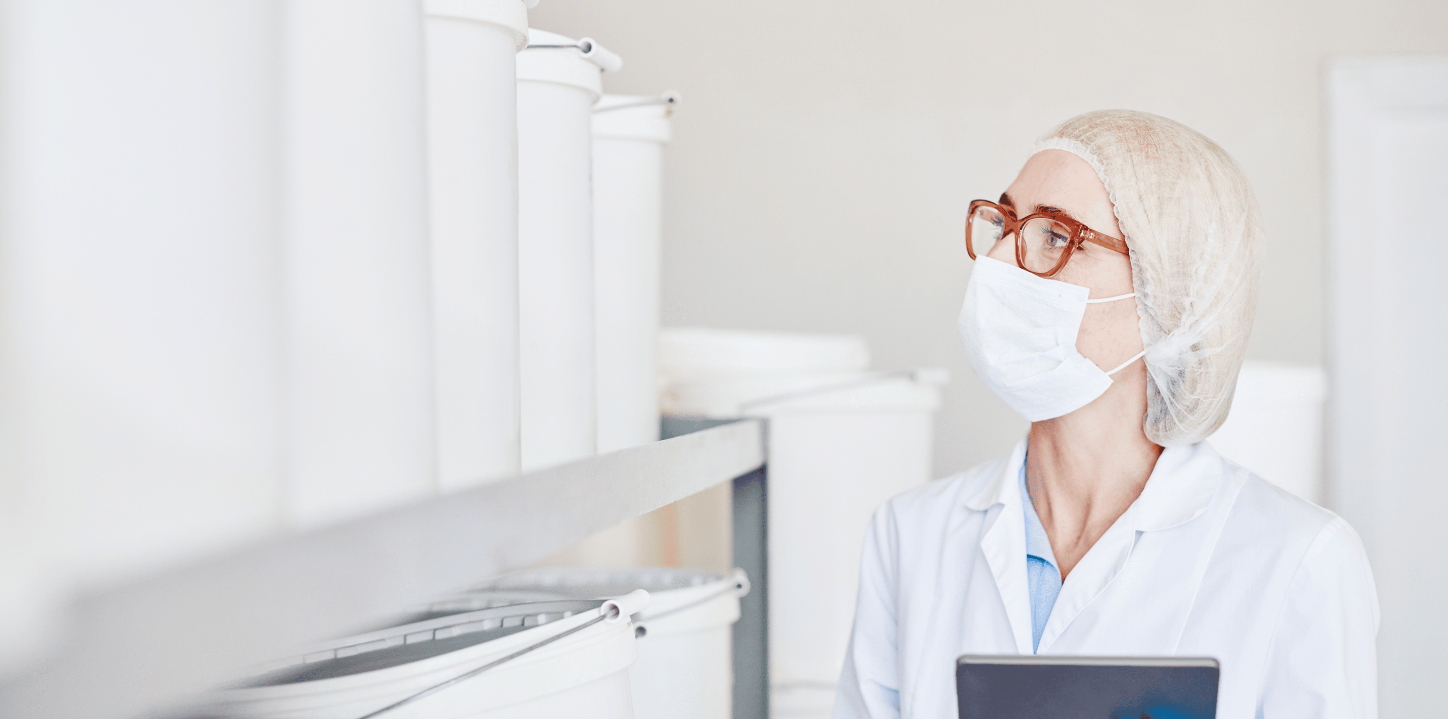 Employee inspecting containers in a cleanroom.