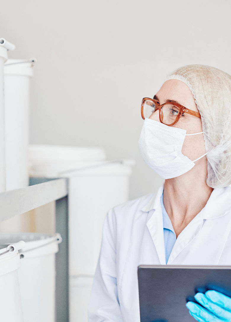 Employee inspecting containers in a cleanroom.
