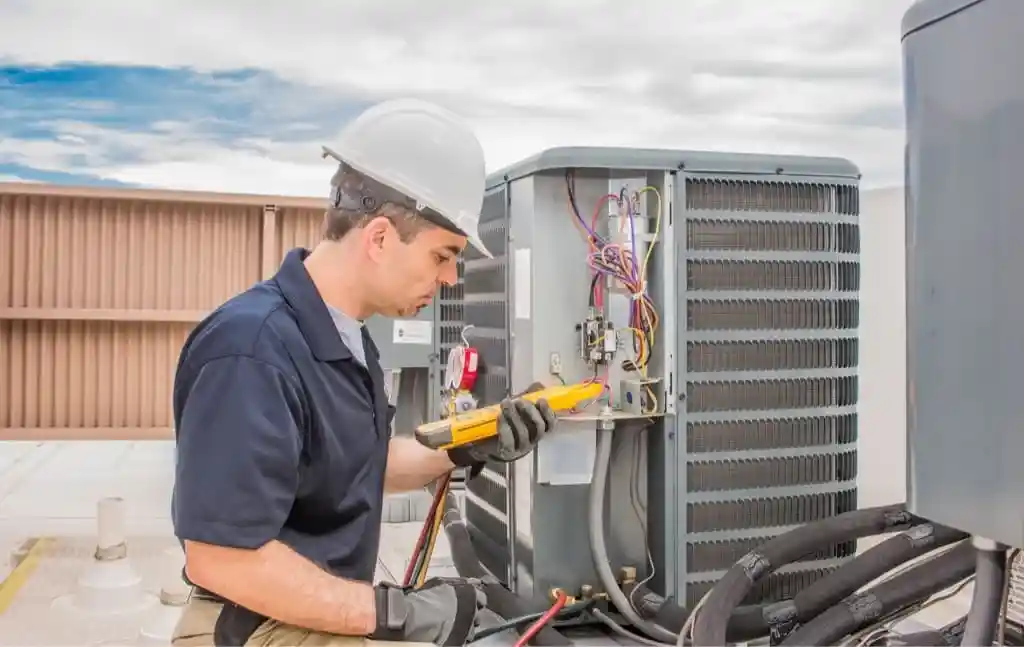 An HVAC tech repairs a rooftop commercial HVAC unit in Tacoma, WA. 