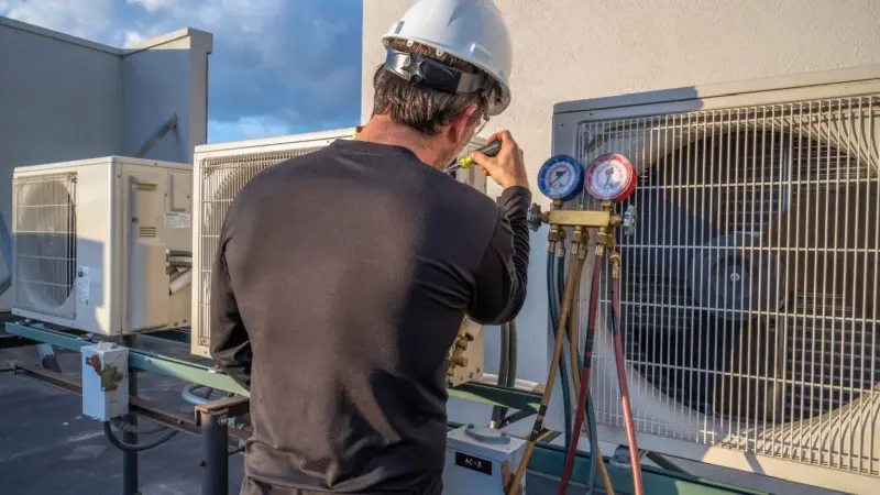 An HVAC tech repairs a rooftop commercial unit in Seattle, WA.