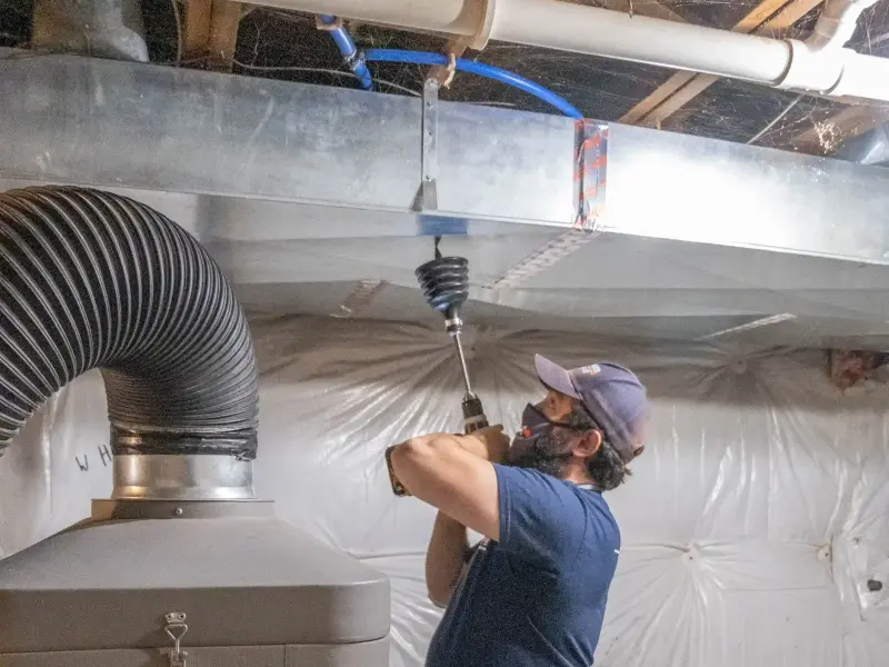 An HVAC tech completes a ductwork installation project in a Fife, WA business. 