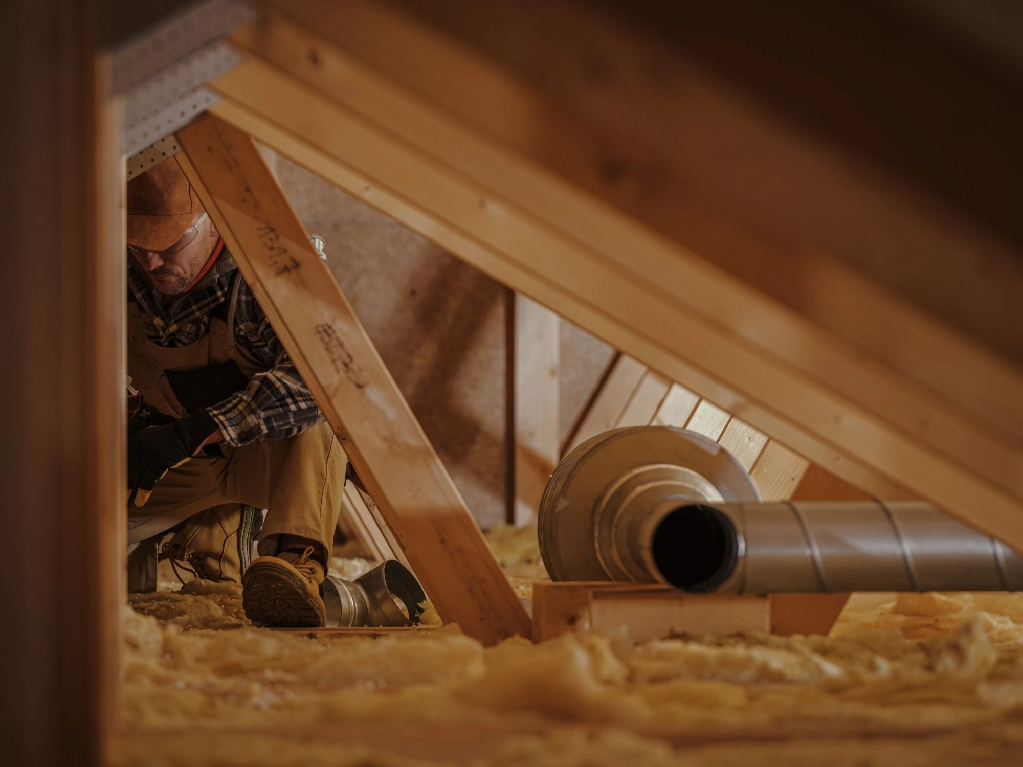 HVAC technician inspecting the attic of a home.