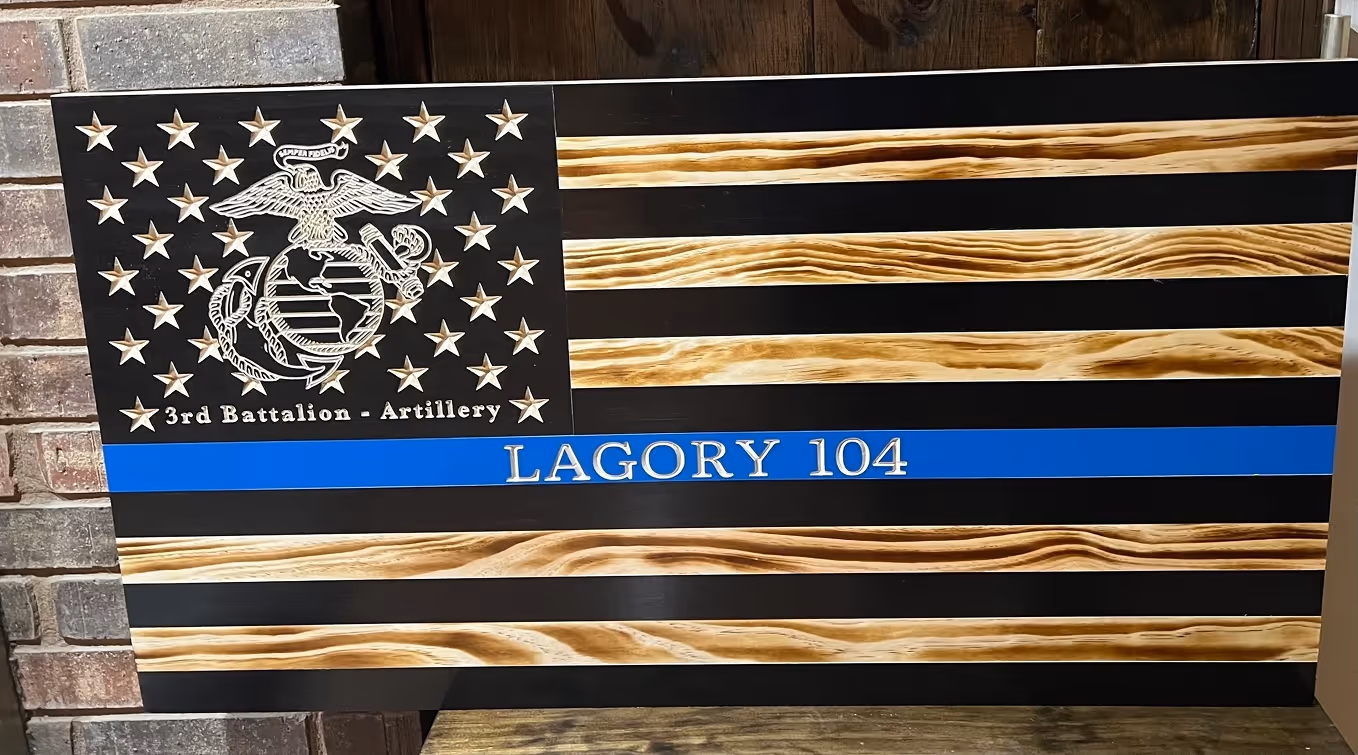 Wood-carved American flag with Marine Corps emblem and text '3rd Battalion - Artillery' and 'LAGORY 104' on a blue stripe.