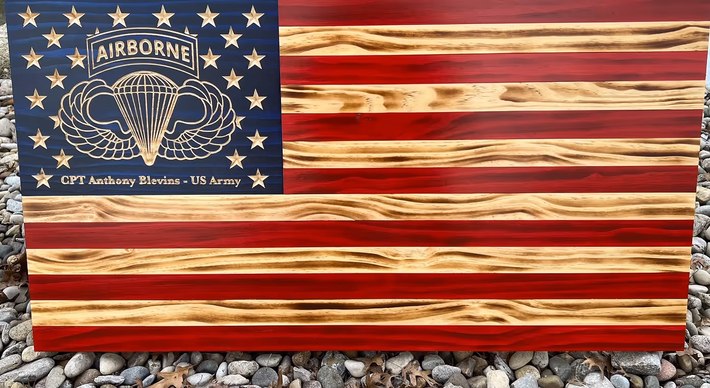 Wooden American flag carved with Airborne wings, stars, and text honoring CPT Anthony Blevins - US Army.
