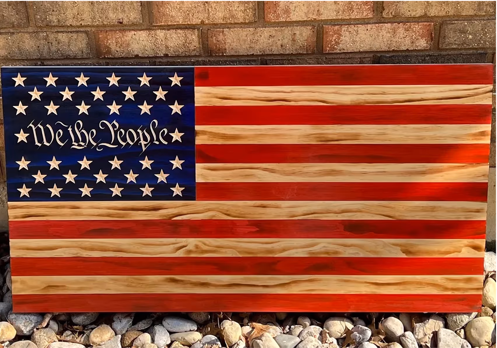 Wooden American flag with 50 stars and the words 'We the People' engraved in the blue field.