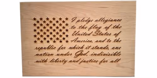 Wooden plaque with American flag stars and the Pledge of Allegiance engraved in cursive script.
