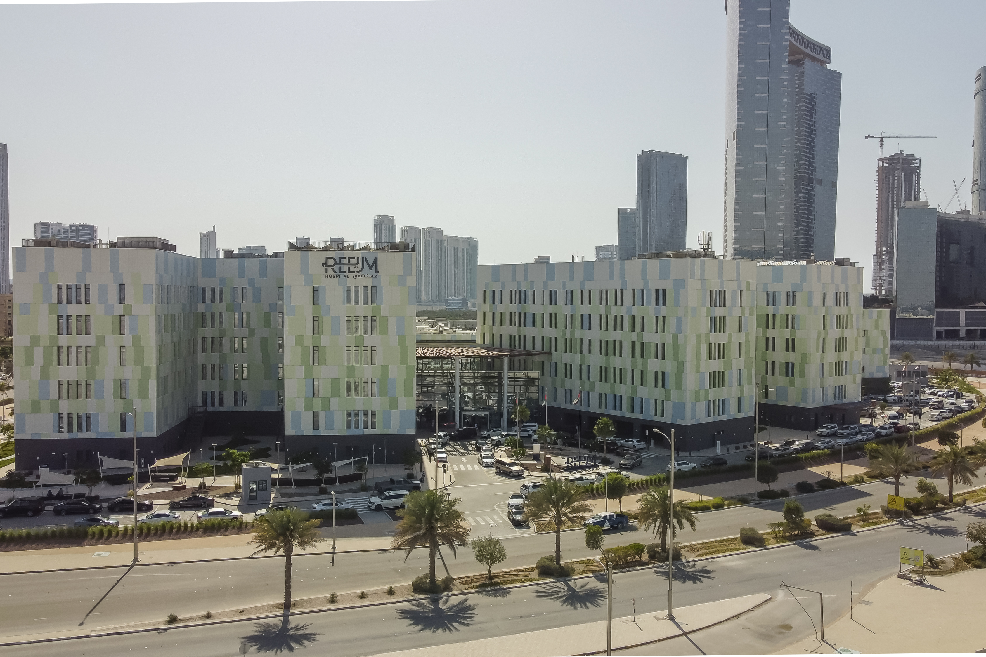 Reem Hospital building with its green and blue panelled facade on Al Reem Island | Rebuilding Syria Platform