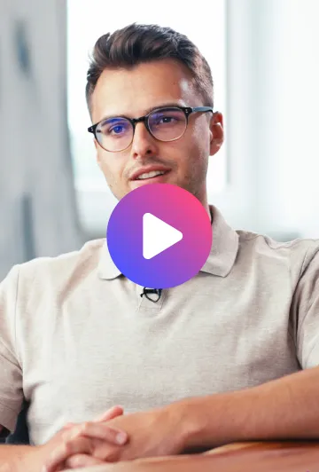 Mann mit Brille und beigem Polohemd spricht, im Hintergrund ein helles Fenster.