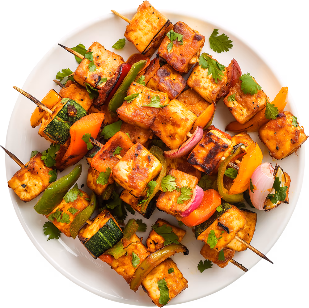 Paneer Tikka skewers on a plate.