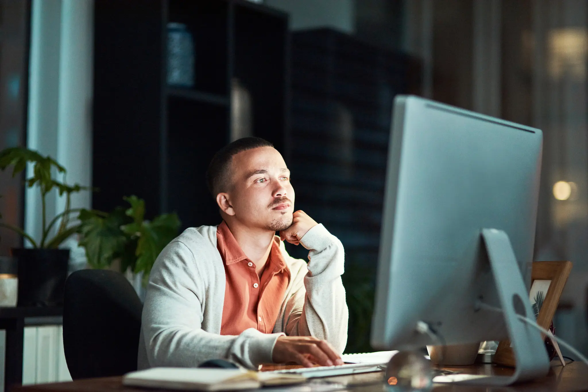 A man sitting at a desk in front of a computer.