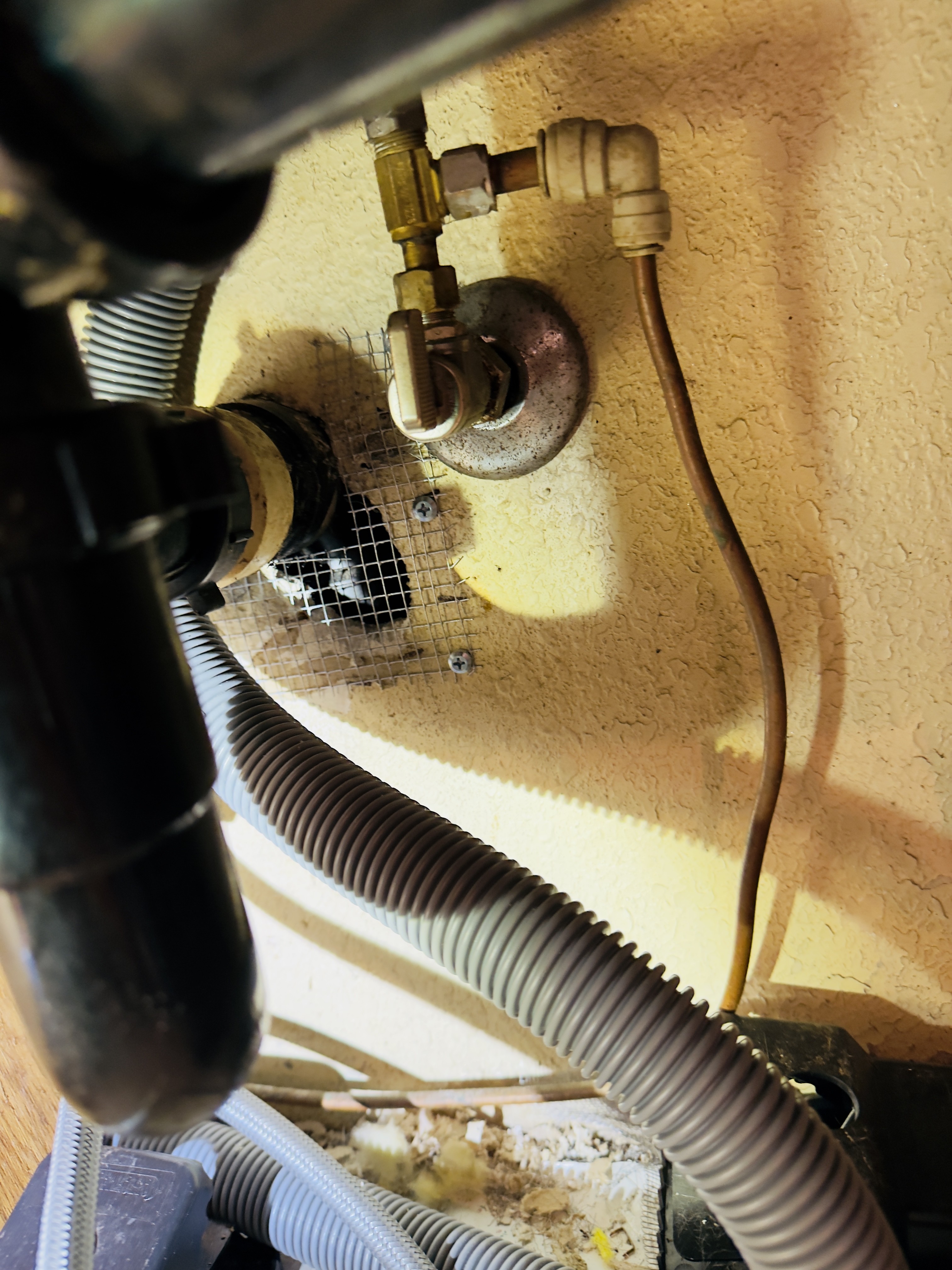 Quarter-inch metal hardware cloth securing an opening around kitchen sink plumbing