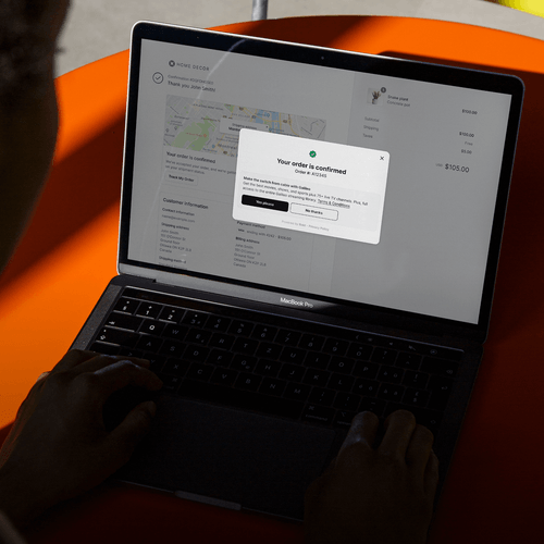 A MacBook Pro laptop showing an order confirmation webpage with customer details, a map, and a pop-up about switching services.