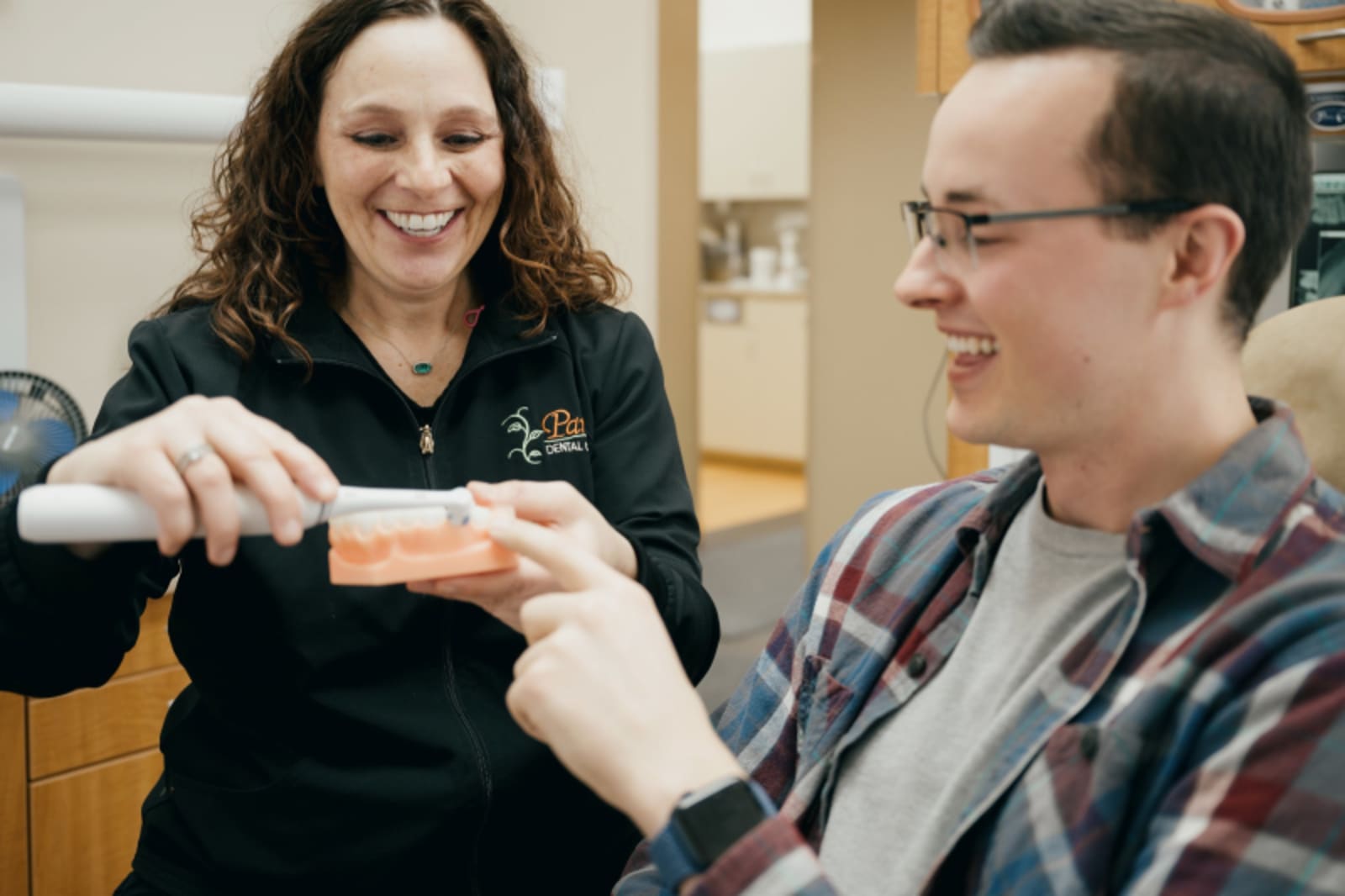 Female dentist smiling and engaging with patient in clinical setting