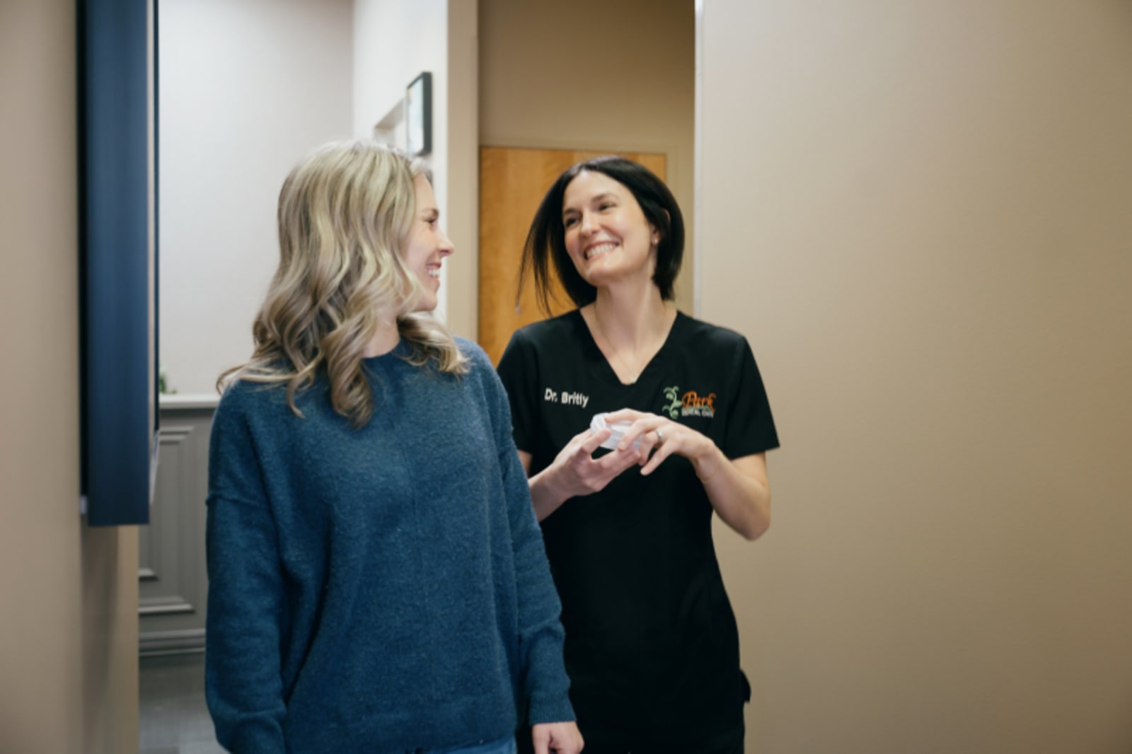 Dentist demonstrating digital scanning technology to patient in treatment room