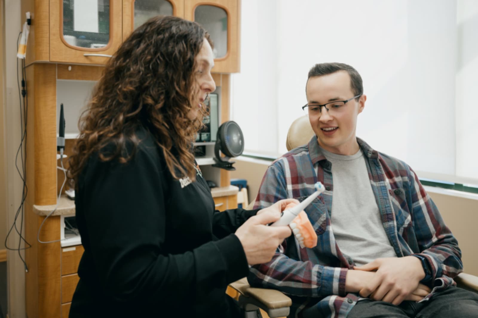 Female dentist and male patient discussing treatment options together