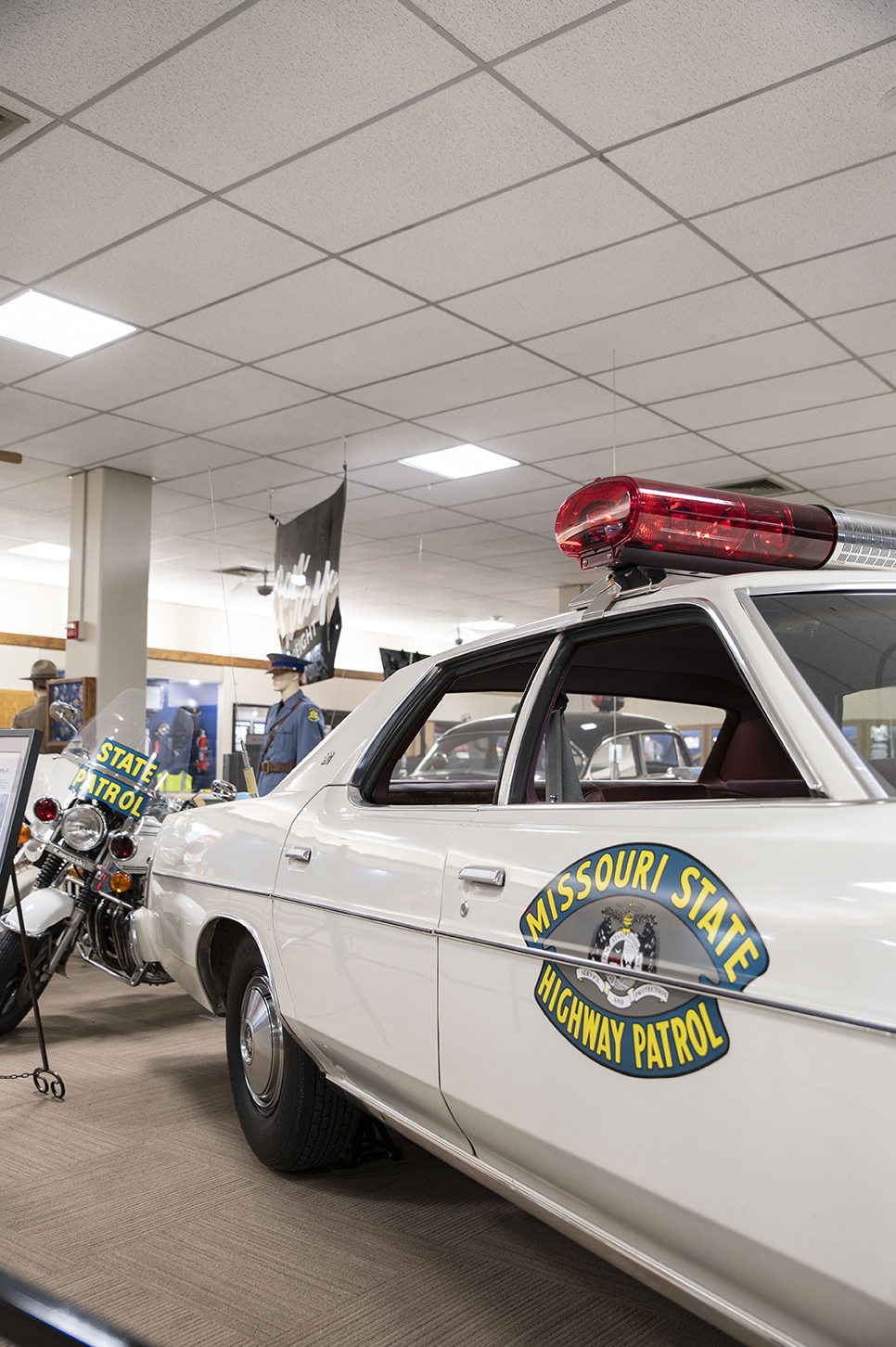 An old Highway Patrol vehicle sits on the museum showroom floor.