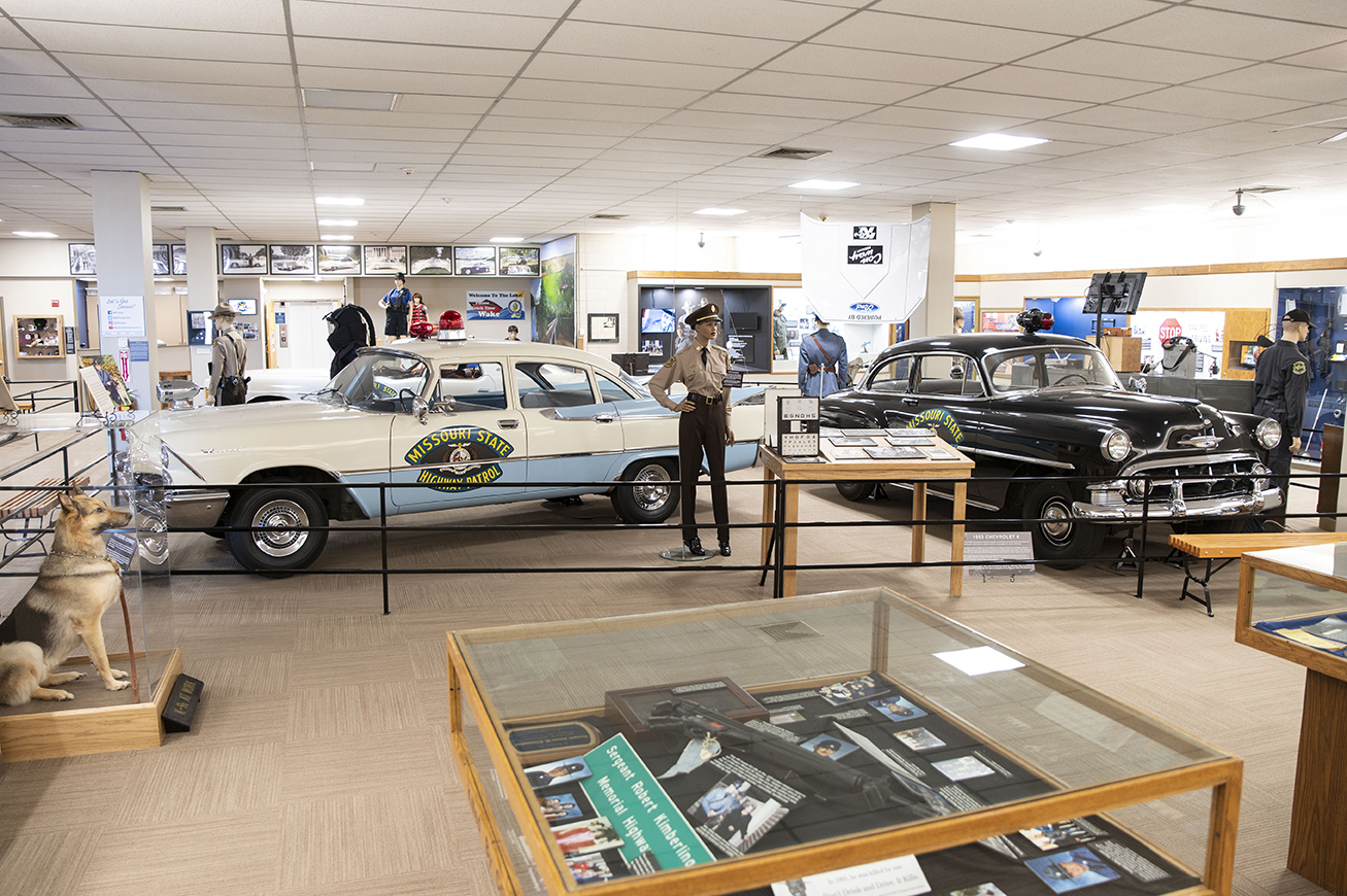 A wide view of MSHP museum displays, including old vehicles.