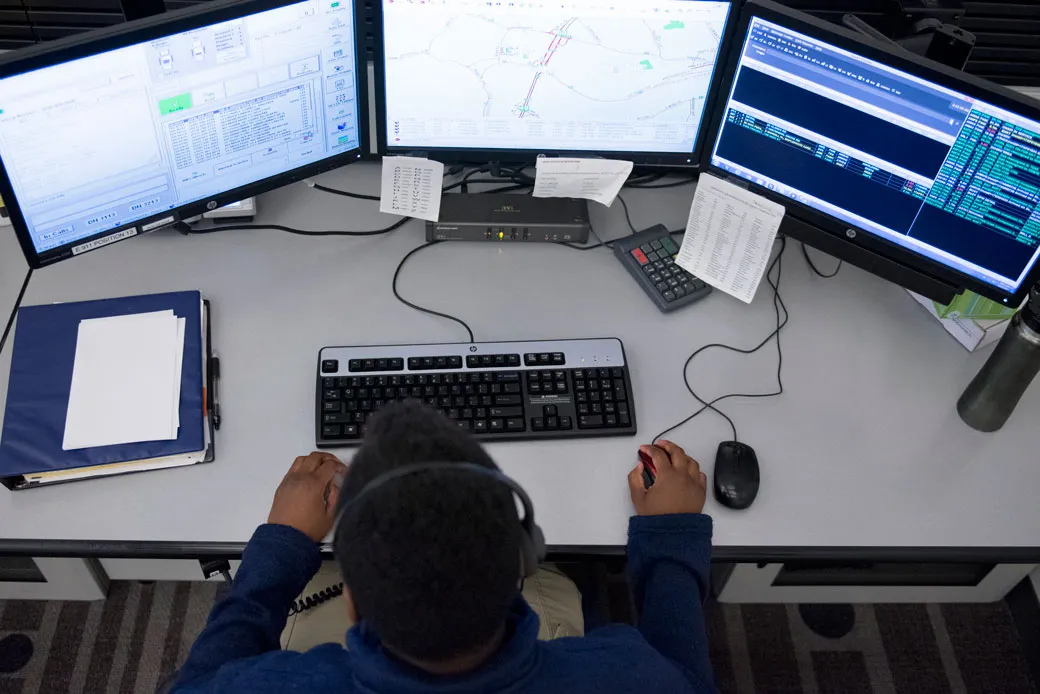An african american male reads reports on his computer.