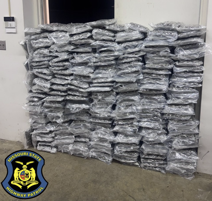 A large stack of seized drugs sits piled against a wall.