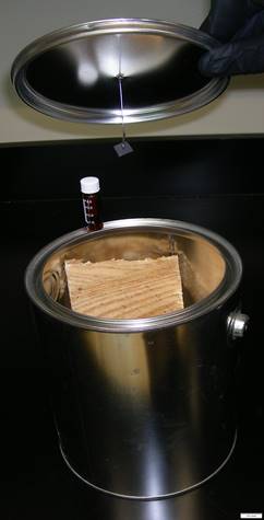 A metal paint can containing fire debris, with an activated charcoal strip suspended from the lid.