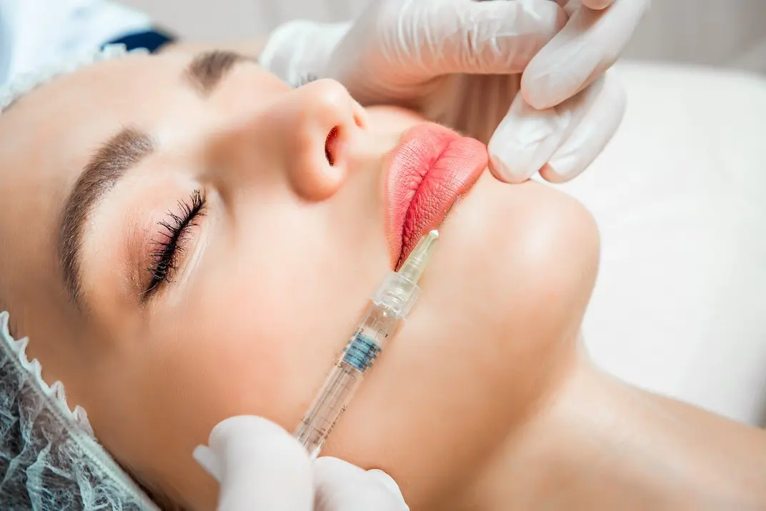 The doctor cosmetologist makes the Rejuvenating facial injections procedure for tightening and smoothing wrinkles on the face skin of a beautiful, young woman in a beauty salon