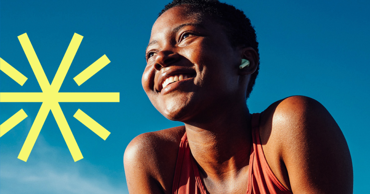 Woman outdoors smiling with abstract spark behind, symbolizing vitality and strength