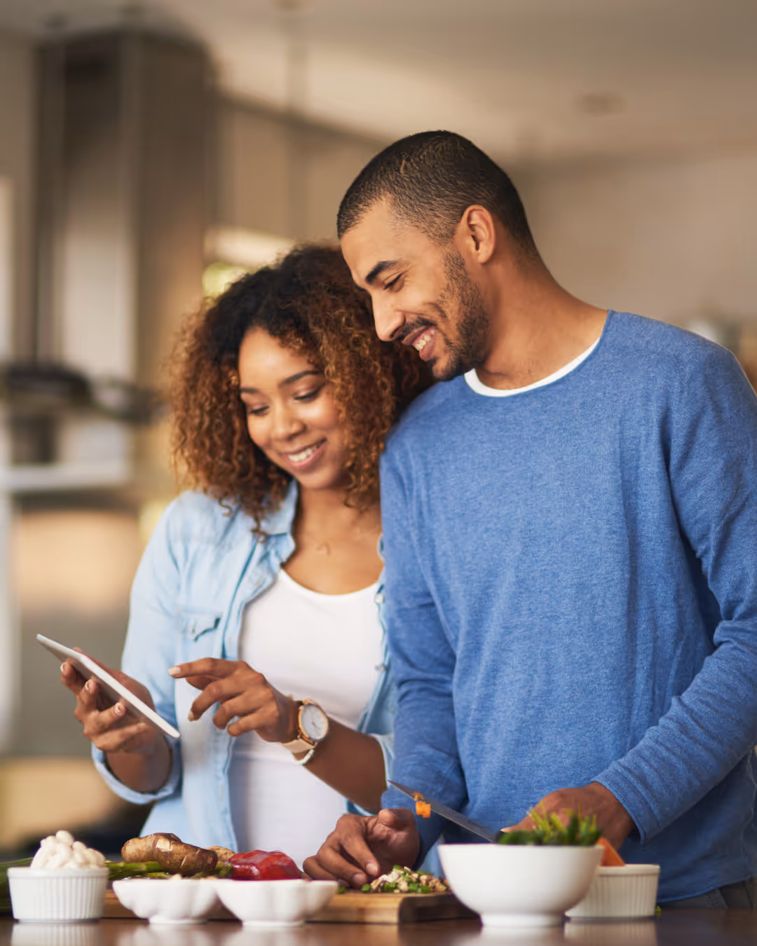 Couple preparing a healthy meal together in a bright kitchen, representing balanced eating habits and supportive wellness routines.