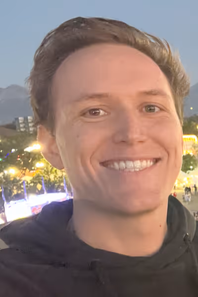 Smiling woman with long curly blonde hair wearing clear-framed glasses and a blue top.