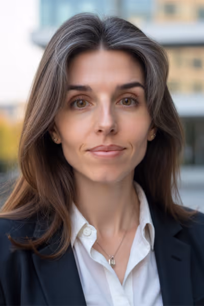 Smiling woman with long curly blonde hair wearing clear-framed glasses and a blue top.